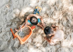 two kids playing on the beach showing that Vacations After Divorce are totally doable with five easy tips