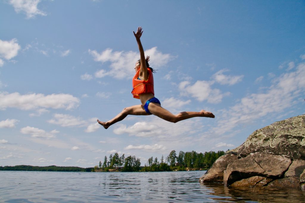 A woman jumping into a pond as an example of putting on a brave face after divorce