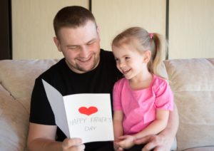 A child and his daughter happily celebrating Father's Day after divorce - our five tips can help make this a reality.