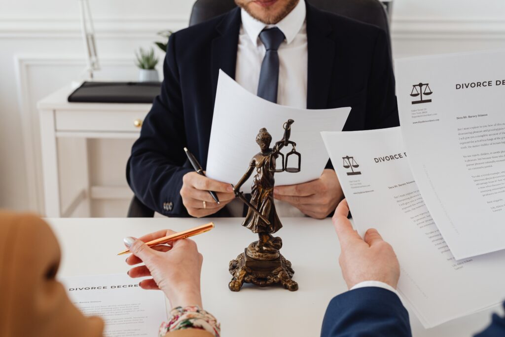 People holding divorce paperwork before an attorney after learning how to file for divorce in Massachusetts.