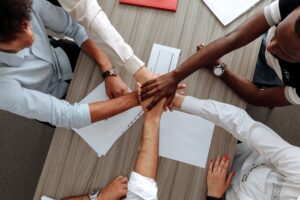 A group of people clasping hands and working together as your divorce professional network.