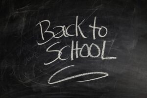 A chalkboard with the words back to school - use our back-to-school tips for divorcing moms for a less stressful experience for everyone.