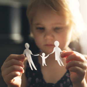 Our five tips for helping children cope with divorce may prevent the forlorn look on this little girl's face as she examines a paper doll family.