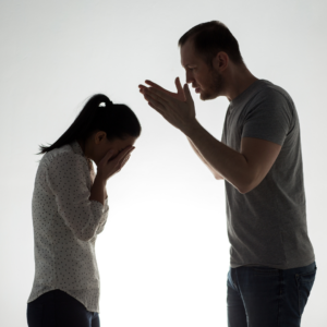 A man looming over a woman in argument - learn some tips for handling divorcing a narcissist.