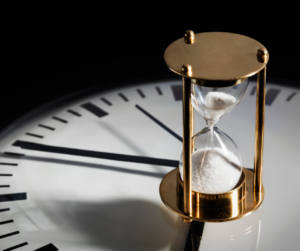 An hourglass set atop of clock representing the question of how long does a divorce take.