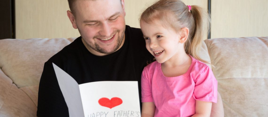 A child and his daughter happily celebrating Father's Day after divorce - our five tips can help make this a reality.