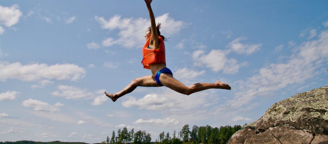 A woman jumping into a pond as an example of putting on a brave face after divorce